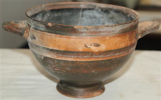 A Greek black slip decorated skyphos, Apulia, c.4th century BC, 22.5cm, broken and re-assembled